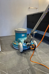 Floor cleaning machine on a tiled surface in an indoor space.