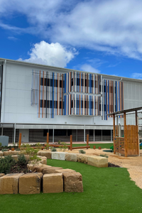 Modern building exterior with colorful vertical accents and landscaped garden.