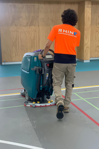 Team member doing floor scrubbing in a school