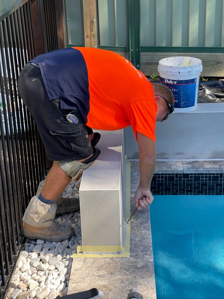 Team member performing externa joint sealing around a swimming pool