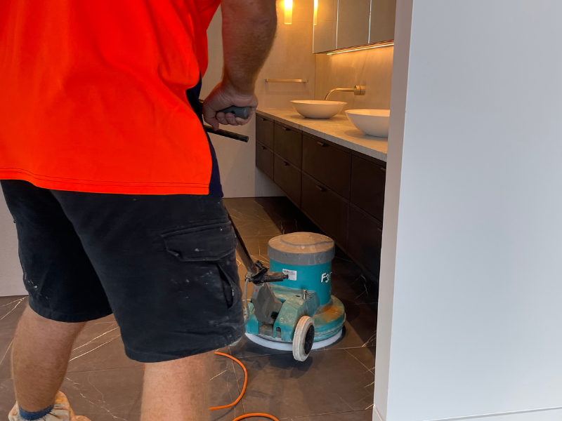 Team member performing a natural stone floor polish